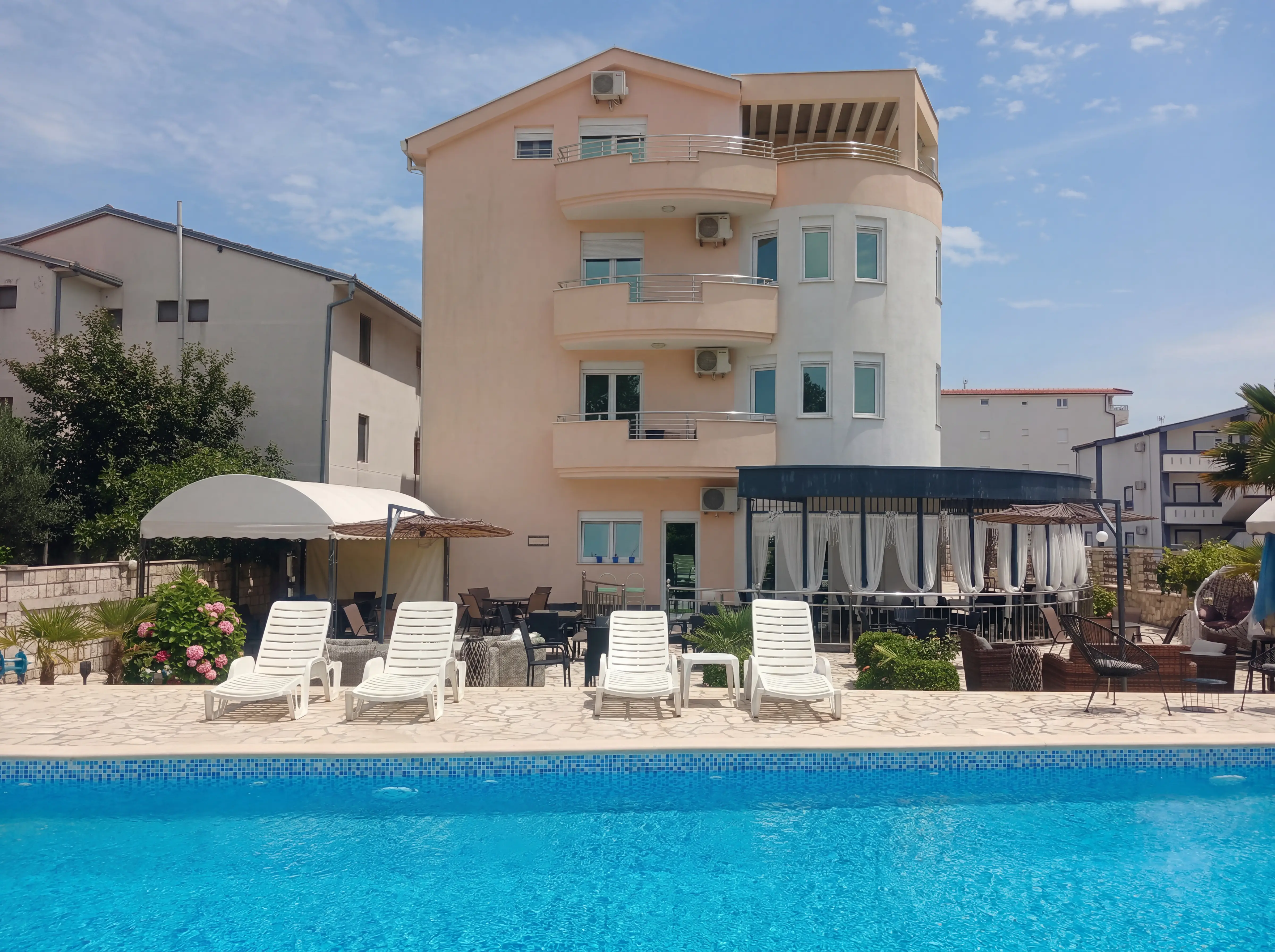Sonniger Poolbereich im Guest House Denis